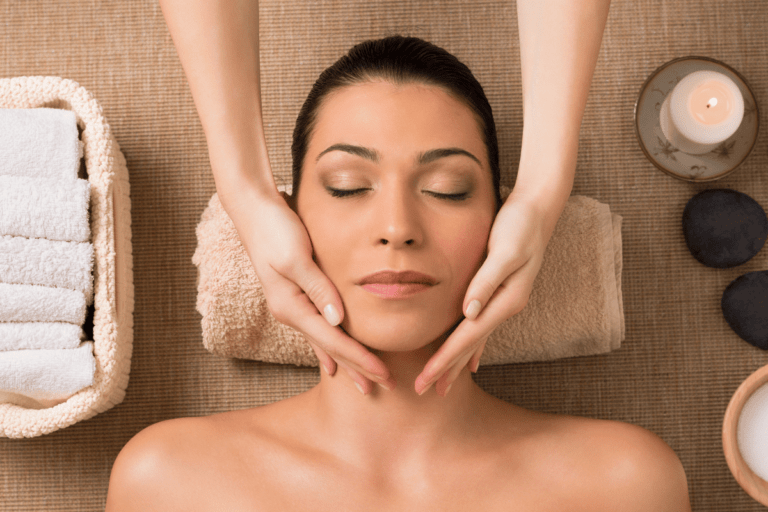 Terapeuta aplicando masaje Kobido en rostro femenino relajado